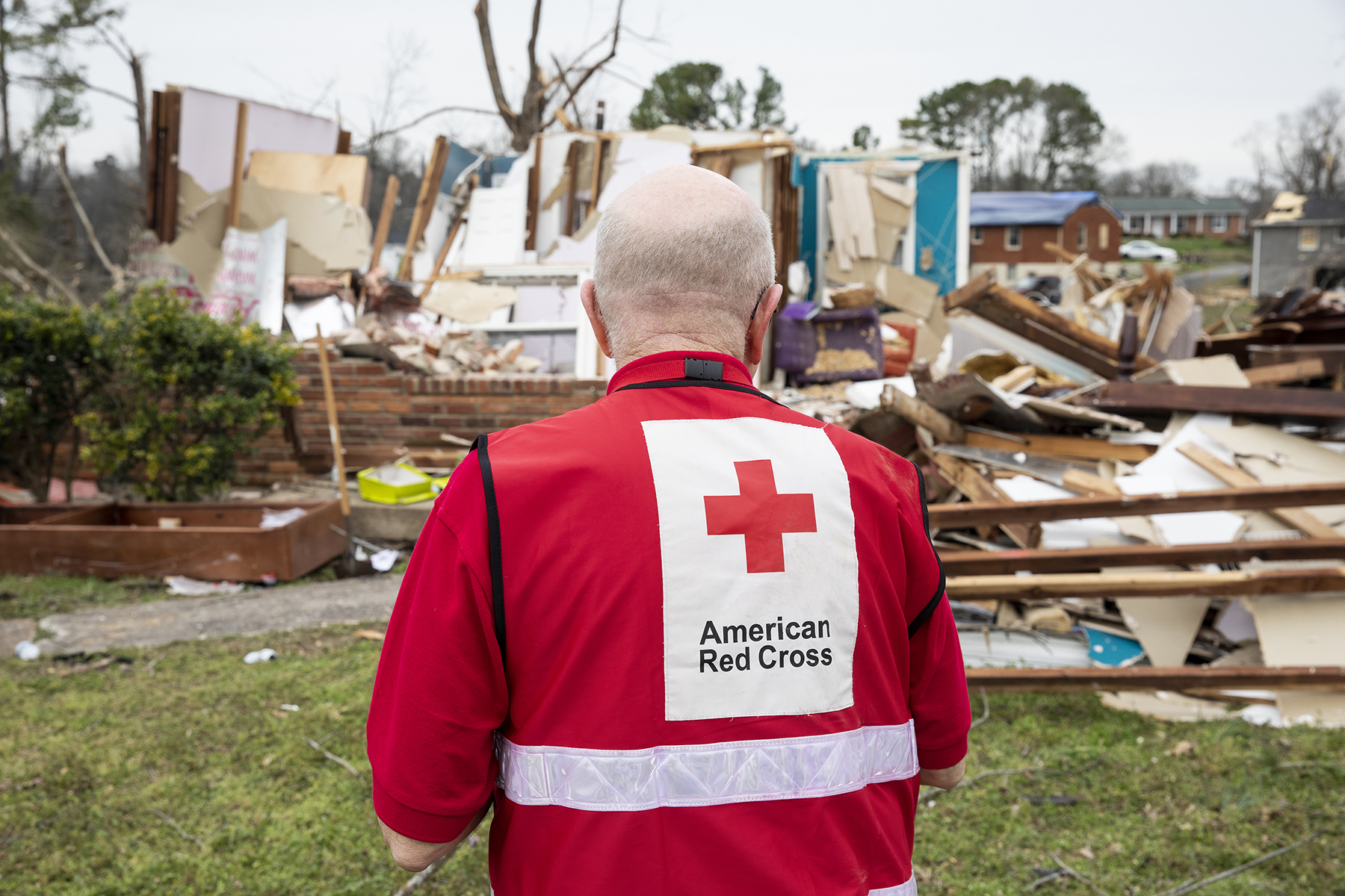 An American Red Cross volunteer surveys tornado damage