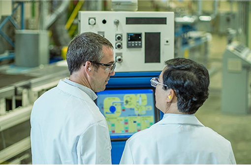 too people wearing goggles and lab coats looking at each other