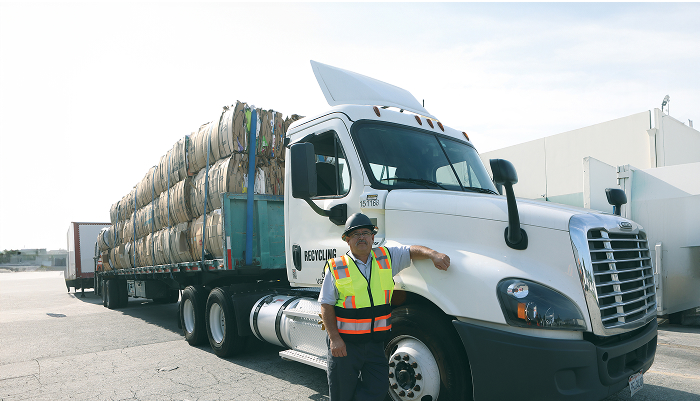 man leaning on a loaded flatbed truck