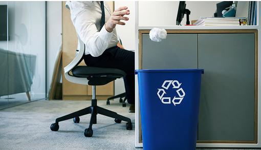 person throwing ball of paper in a recycling bin