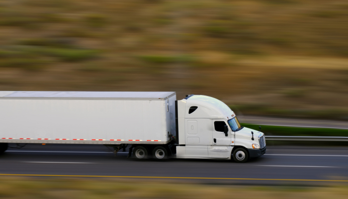 trailer truck moving fast down a highway