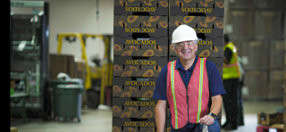 ed arriaga standing in front of avocado boxes