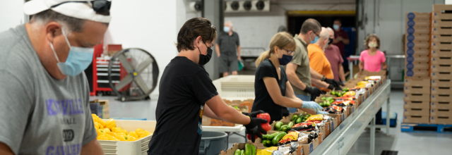 Volunteers prepare boxes of vegetables and fruits to distribute to people experiencing hunger in Canada. (Photo: Food Banks Canada)