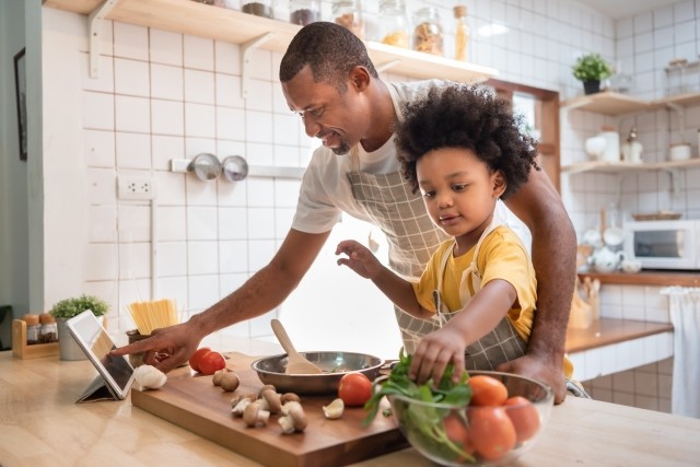 A man cooks dinner with his son