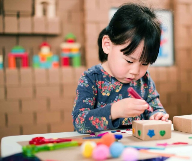 A child crafts with corrugated boxes