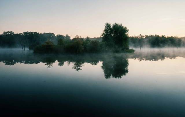 Mist hangs over a lake at dawn