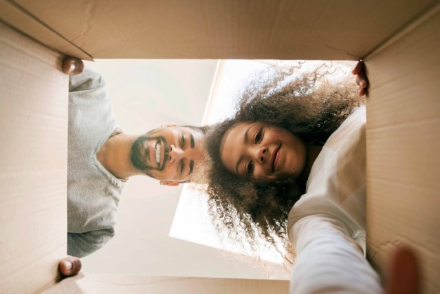 A man and young girl look inside a box.