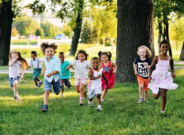 Young children running through a park