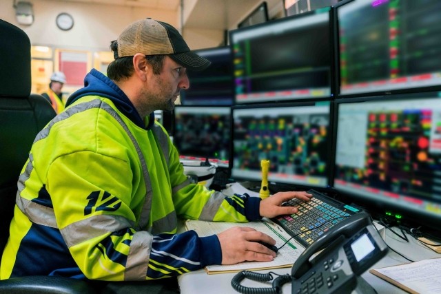 An International Paper employees works at a busy control center