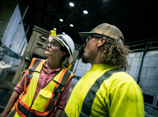 Two employees have a conversation in a paper mill