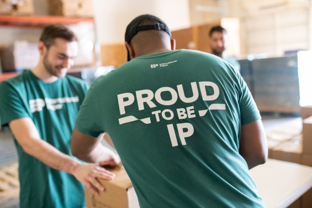 International Paper employee wearing a "Proud to be IP" shirt while supporting a community engagement event.