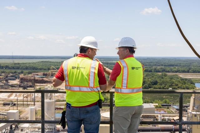 Andy Silvernail speaks to an employee atop a mill tower overlooking a rural landscape