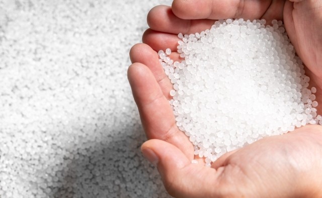 bulk amounts of resin pellets in someone's hands