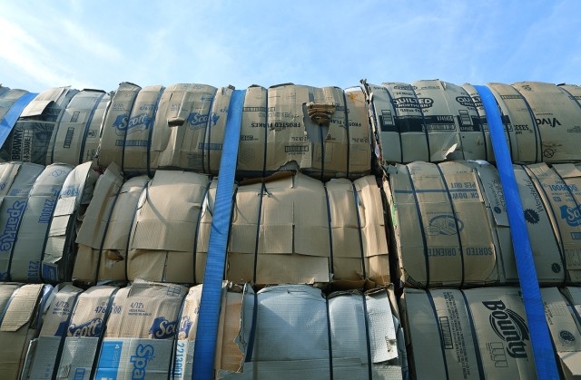multiple stacks of bales wrapped in paper and secured by a safety belts