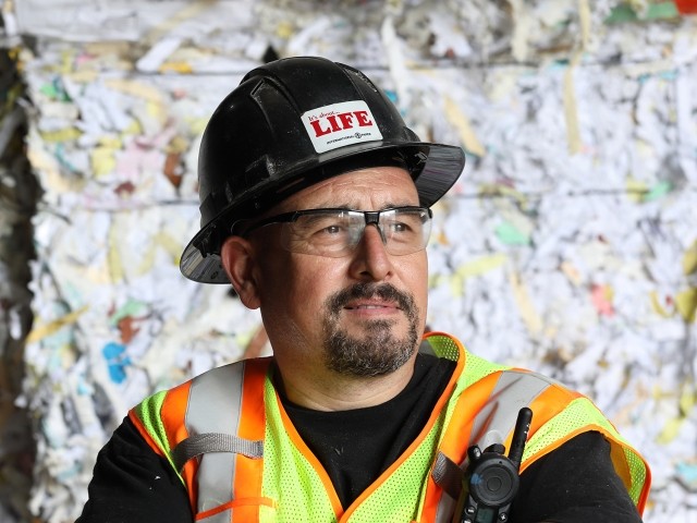Close-up of a worker in a safety vest and a hard hat